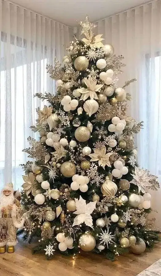 Brad artificial verde decorat cu flori albe și globuri aurii