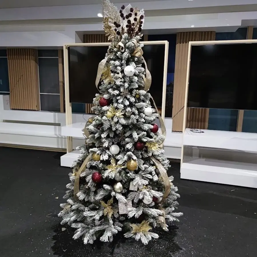 Brad artificial plin de decorațiuni colorate, aducând bucurie în casă.