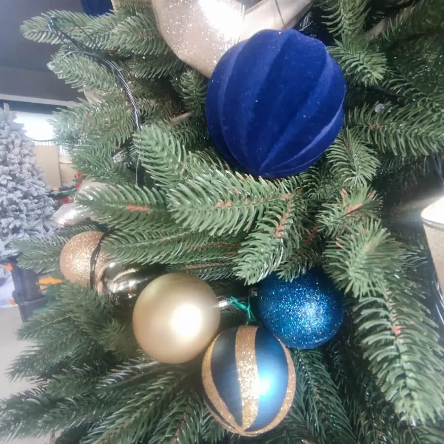 Imagine de ansamblu a unui living de Crăciun, cu bradul artificial ca piesă centrală.