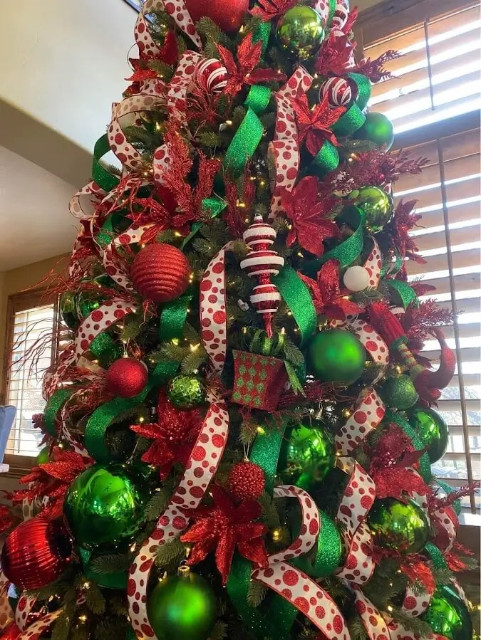 Brad artificial elegant, decorat cu panglici și globuri în nuanțe de crem și auriu.